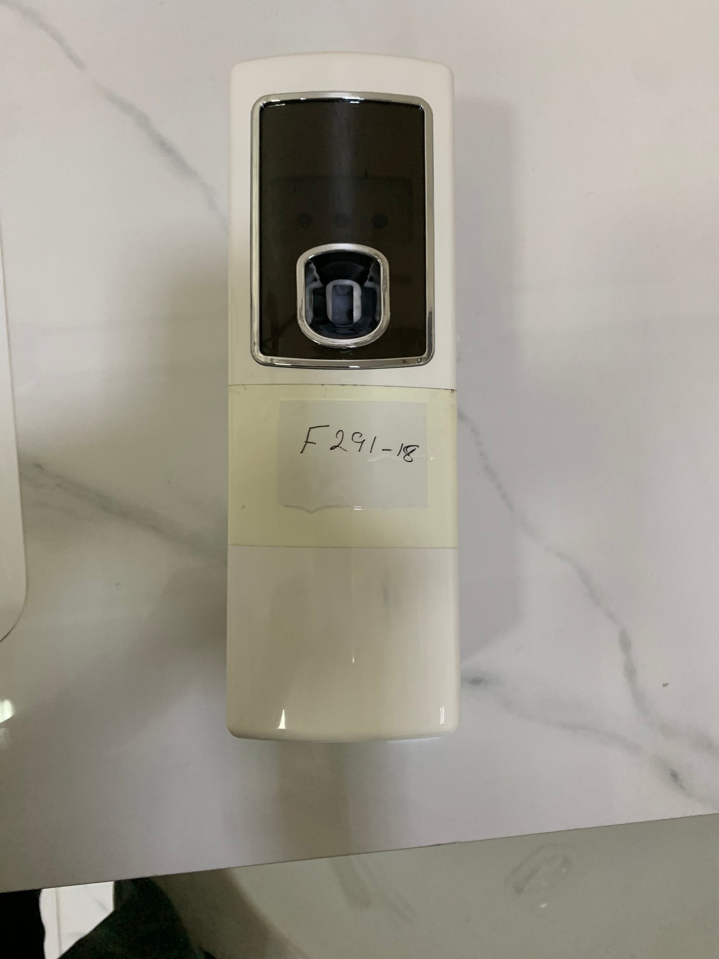 Automatic aerosol dispenser air freshener is wall-mounted